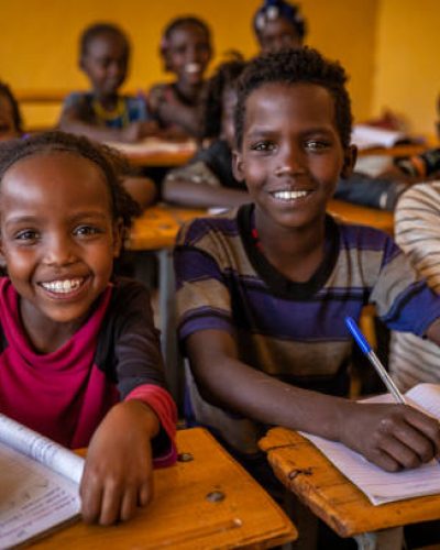 African children during english class in very remote school. The building is new, but still there is no light and electricity inside the classroom.